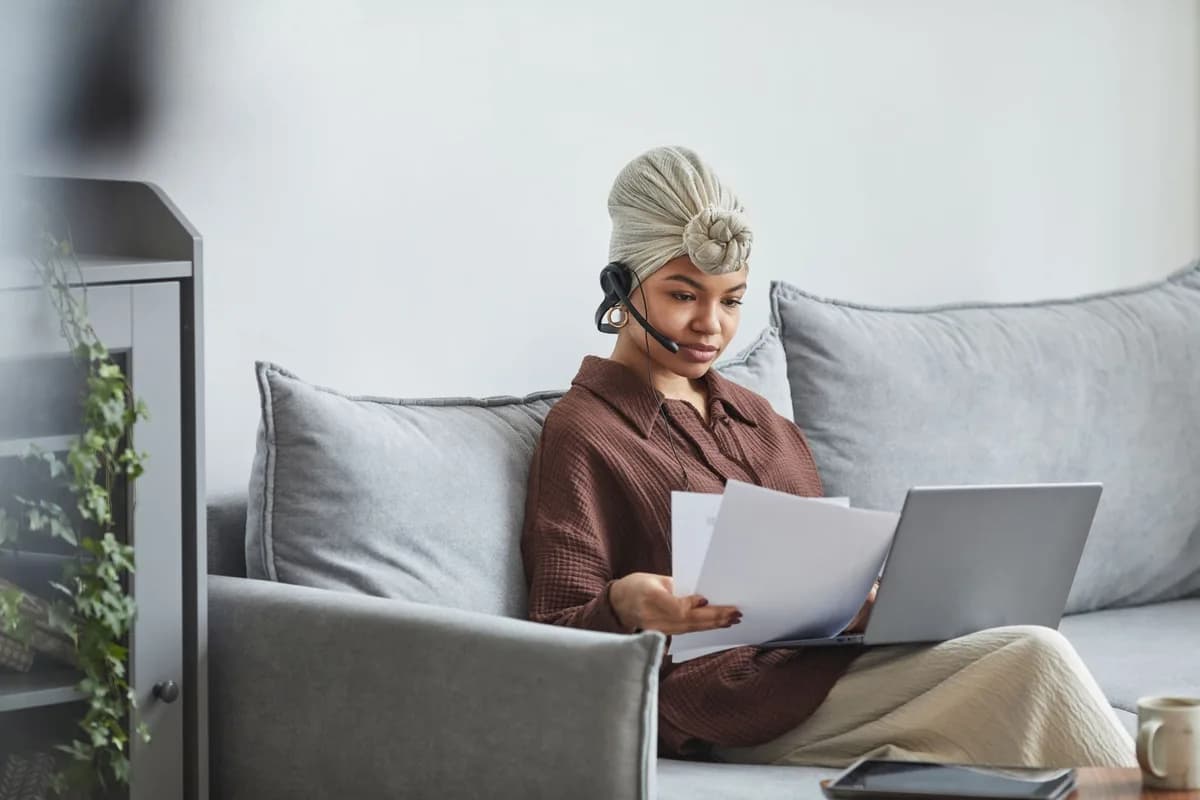Une professionnelle consulte des documents devant son ordinateur.